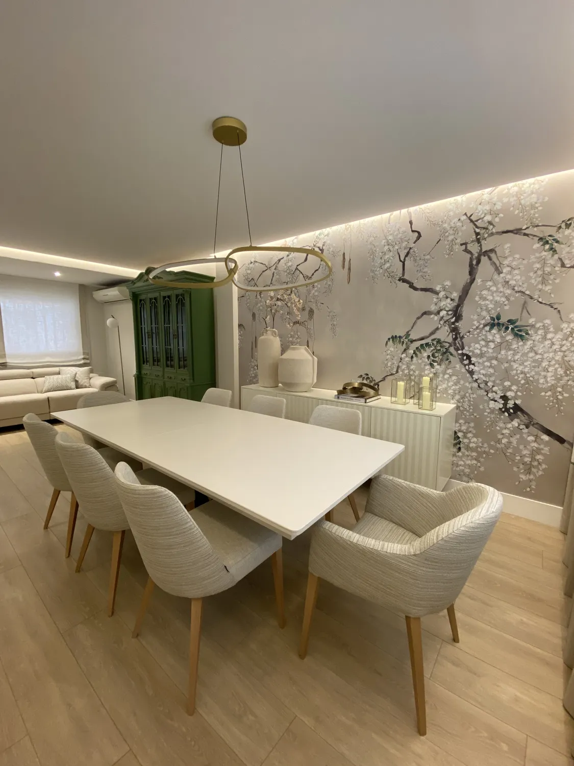 Comedor con papel mural botánico, vitrina verde e iluminación indirecta, vivienda en alcalá