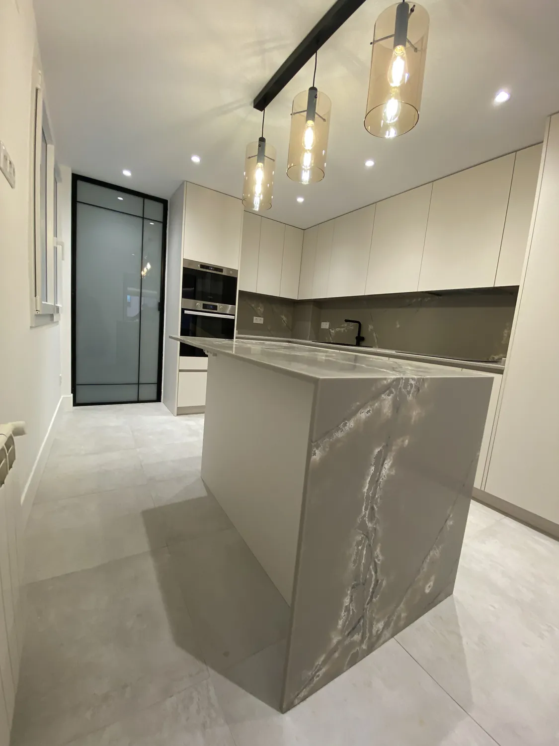 Isla de cocina con acabado efecto mármol en cascada, vivienda en Atocha