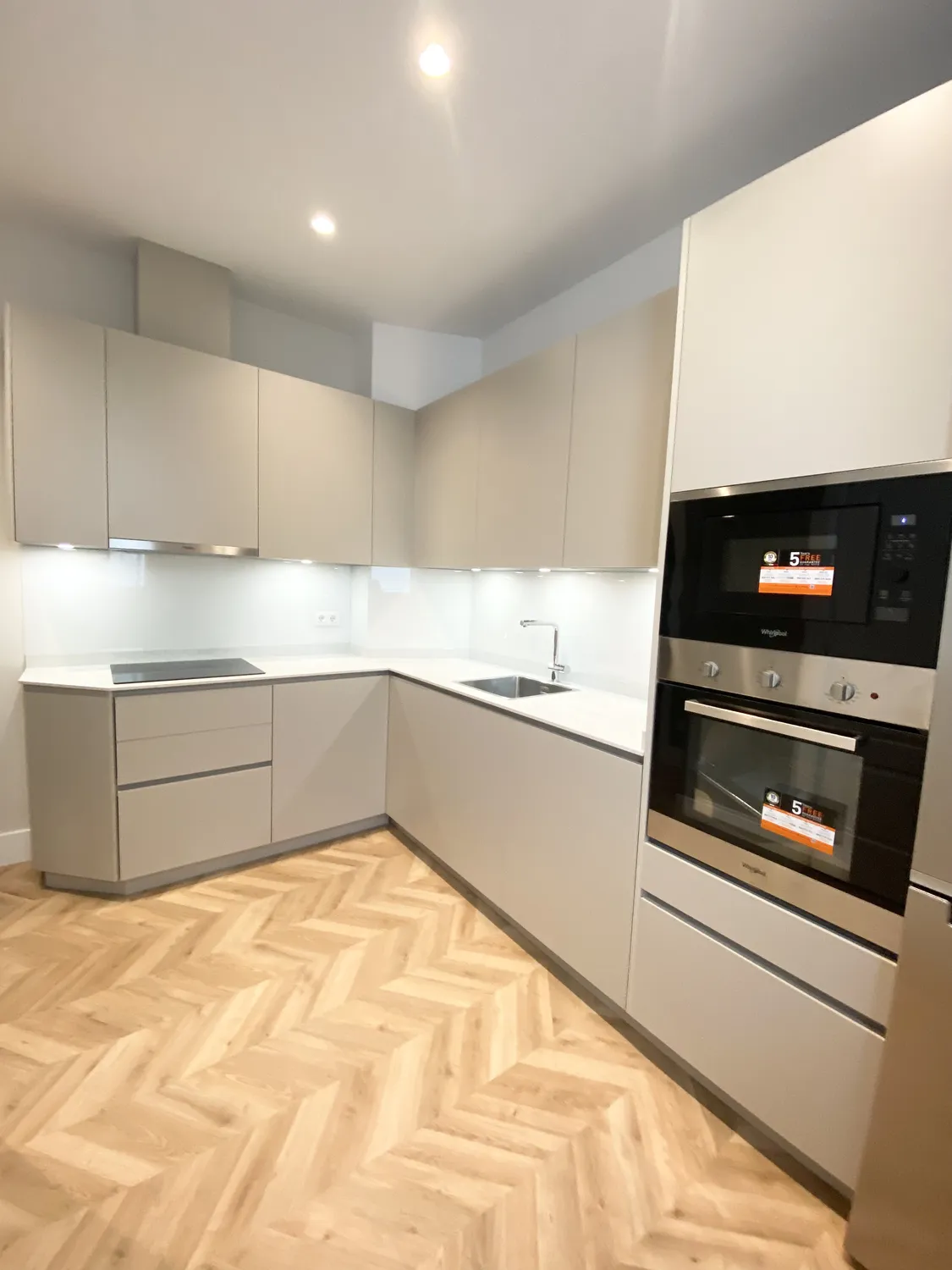 Cocina en tonos topo con suelo de madera en espiga, vivienda en conde de peñalver